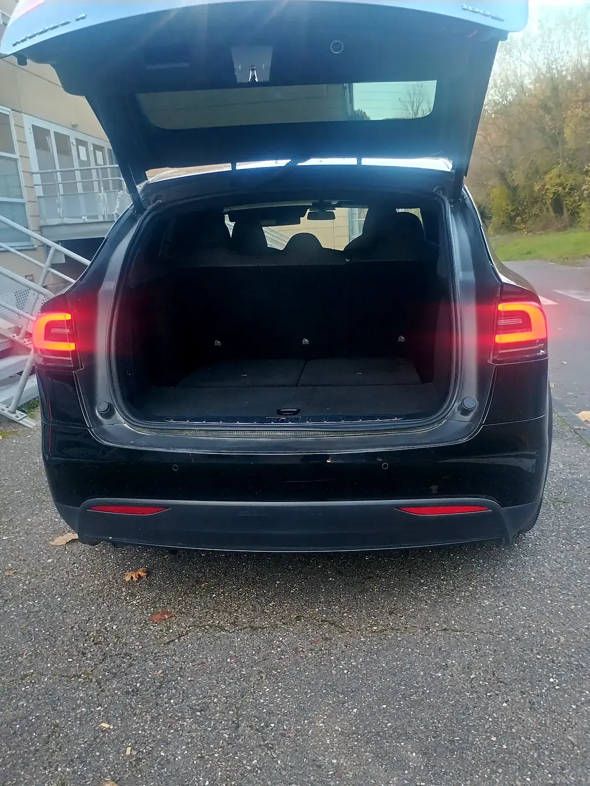 Le coffre de la Tesla Model X noire de PrestigeGo, hayon levé, plancher plat et dossiers de la banquette